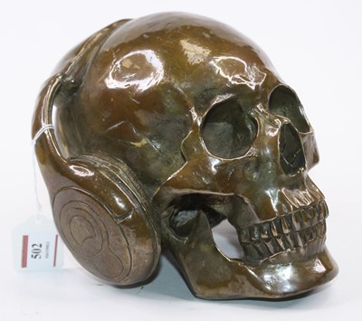 Lot 502 - A modern bronzed model of a skull wearing...