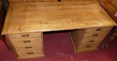 Lot 1354 - A pine kneehole writing desk, having twin...
