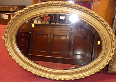 Lot 1076 - A gilt framed and bevelled oval wall mirror,...
