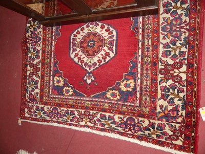 Lot 1200 - A Persian woollen red ground Bokhara rug, the...