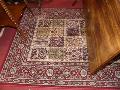 Lot 1204 - A Persian style red ground machine-woven rug,...