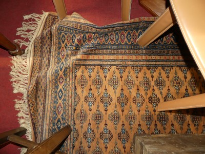 Lot 1205 - A Persian woollen peach ground Bokhara rug,...