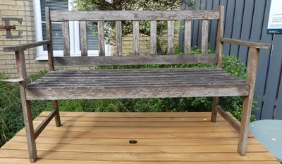 Lot 1546 - A stained and slatted teak two-seater garden...