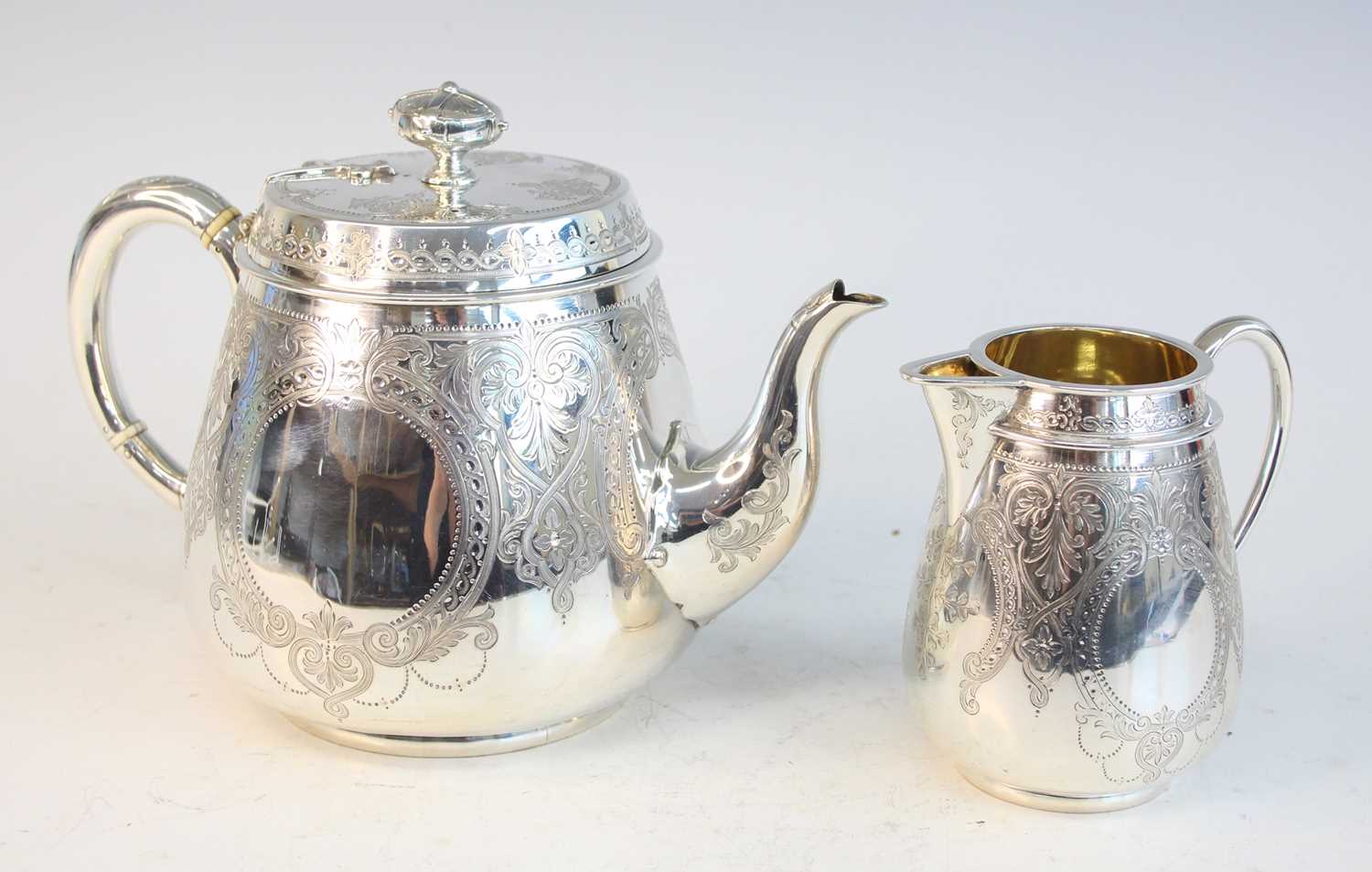 Lot 2092 - A Victorian silver teapot and matching cream,...