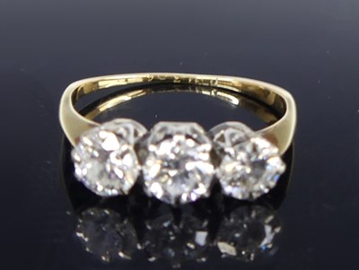 Lot 2801 - An 18ct gold diamond trilogy ring, arranged as...