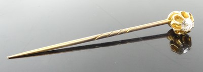 Lot 2606 - A yellow metal diamond stick pin, featuring an...
