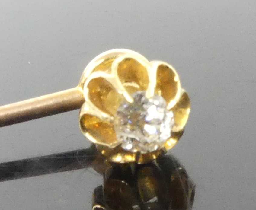 Lot 2606 - A yellow metal diamond stick pin, featuring an...