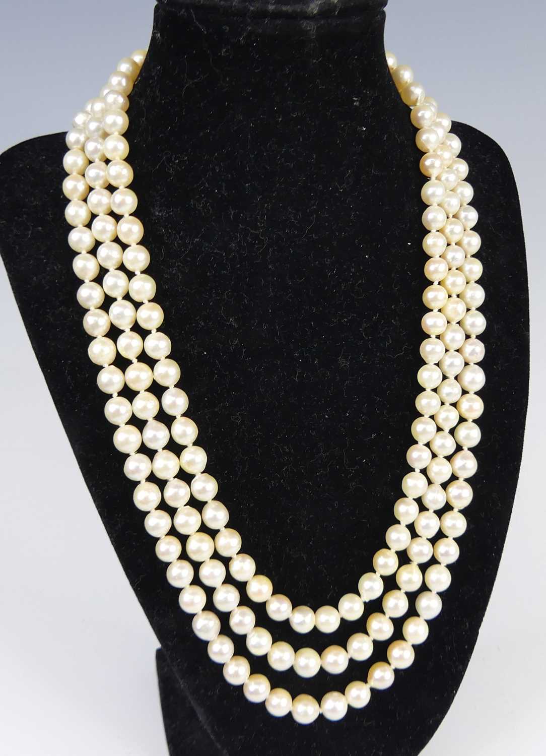 Lot 2609 - A cultured pearl triple string choker, the...