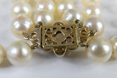 Lot 2609 - A cultured pearl triple string choker, the...