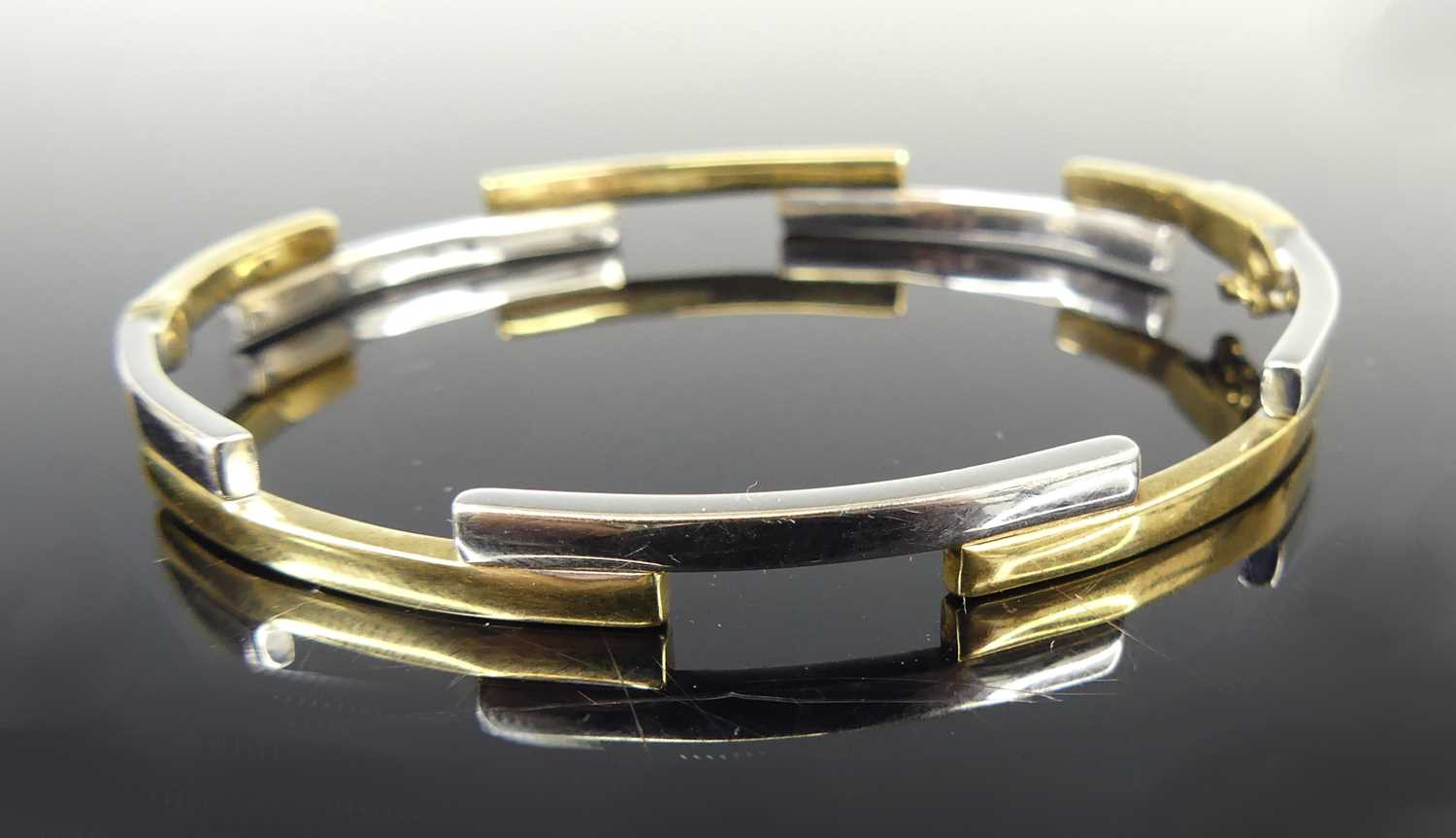 Lot 2612 - A contemporary 9ct yellow and white gold hinge...
