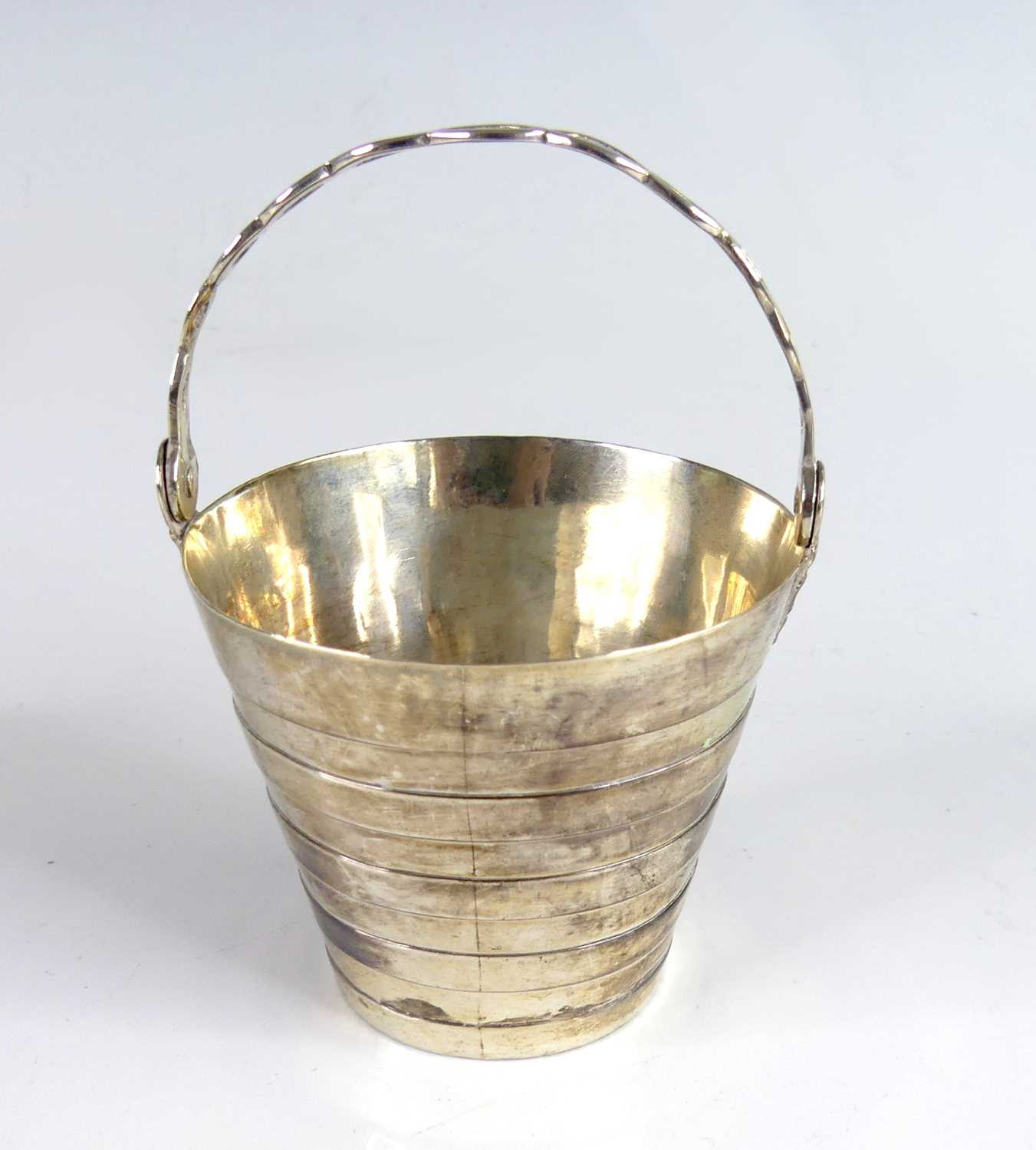 Lot 2074 - A George II silver gilt swing-handled table...
