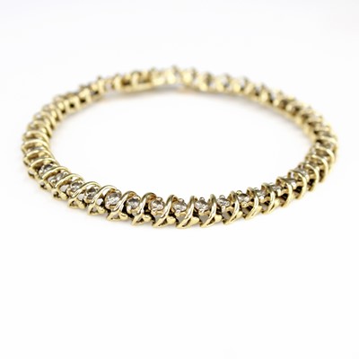 Lot 2098 - A yellow metal diamond line bracelet,...