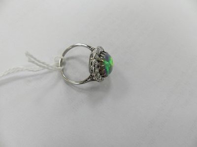 Lot 2073 - A white metal opal and diamond oval cluster...