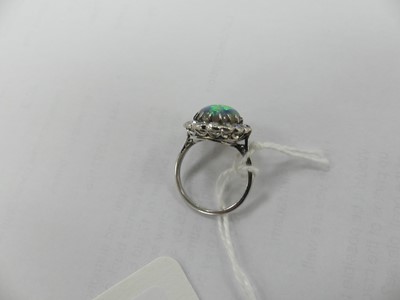 Lot 2073 - A white metal opal and diamond oval cluster...