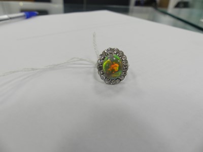 Lot 2073 - A white metal opal and diamond oval cluster...