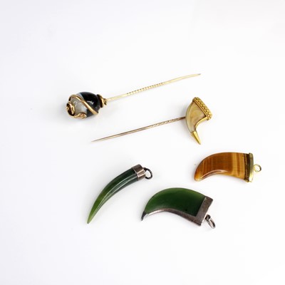 Lot 390 - A yellow metal and agate tie pin, the...