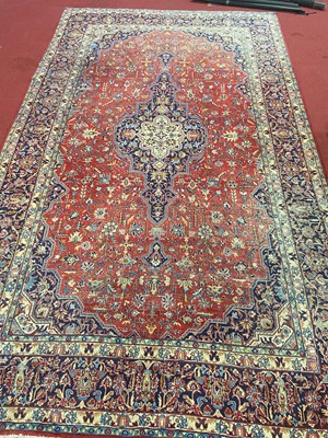 Lot 323 - A Persian woolen tabriz carpet, the red ground...