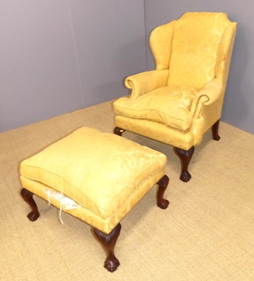 Lot 715 - A yellow floral fabric upholstered wingback...
