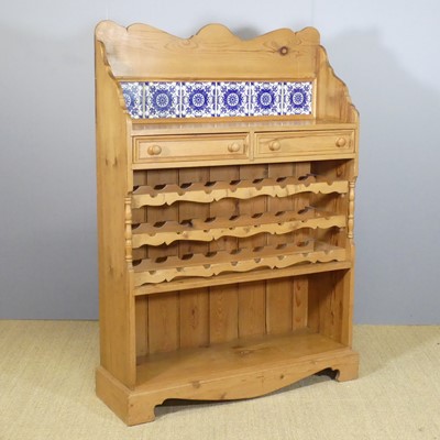 Lot 635 - A rustic pine freestanding open wine rack, the...