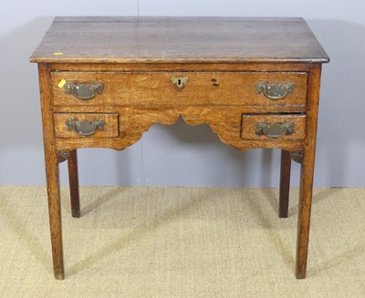 Lot 682 - A provincial George III oak kneehole three...