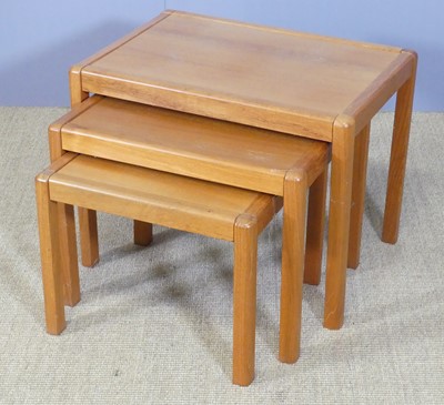Lot 654 - A teak nest of three occasional tables, the...