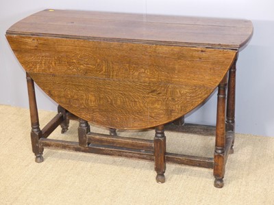 Lot 634 - An antique joined oak drop leaf dining table,...