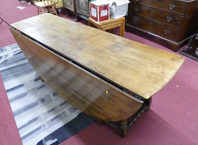 Lot 679 - A large joined oak drop-flap wake table,...